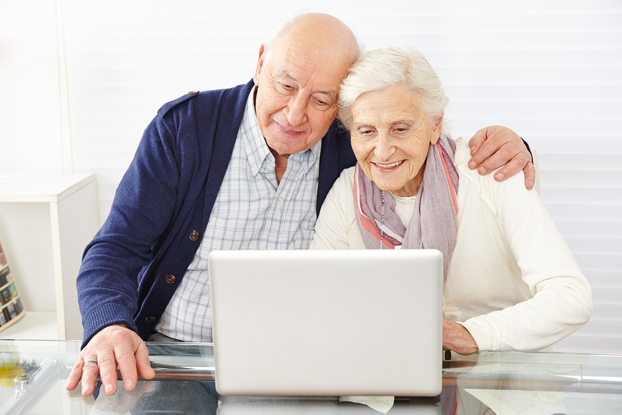 Senior couple using ecommerce in internet with laptop computer